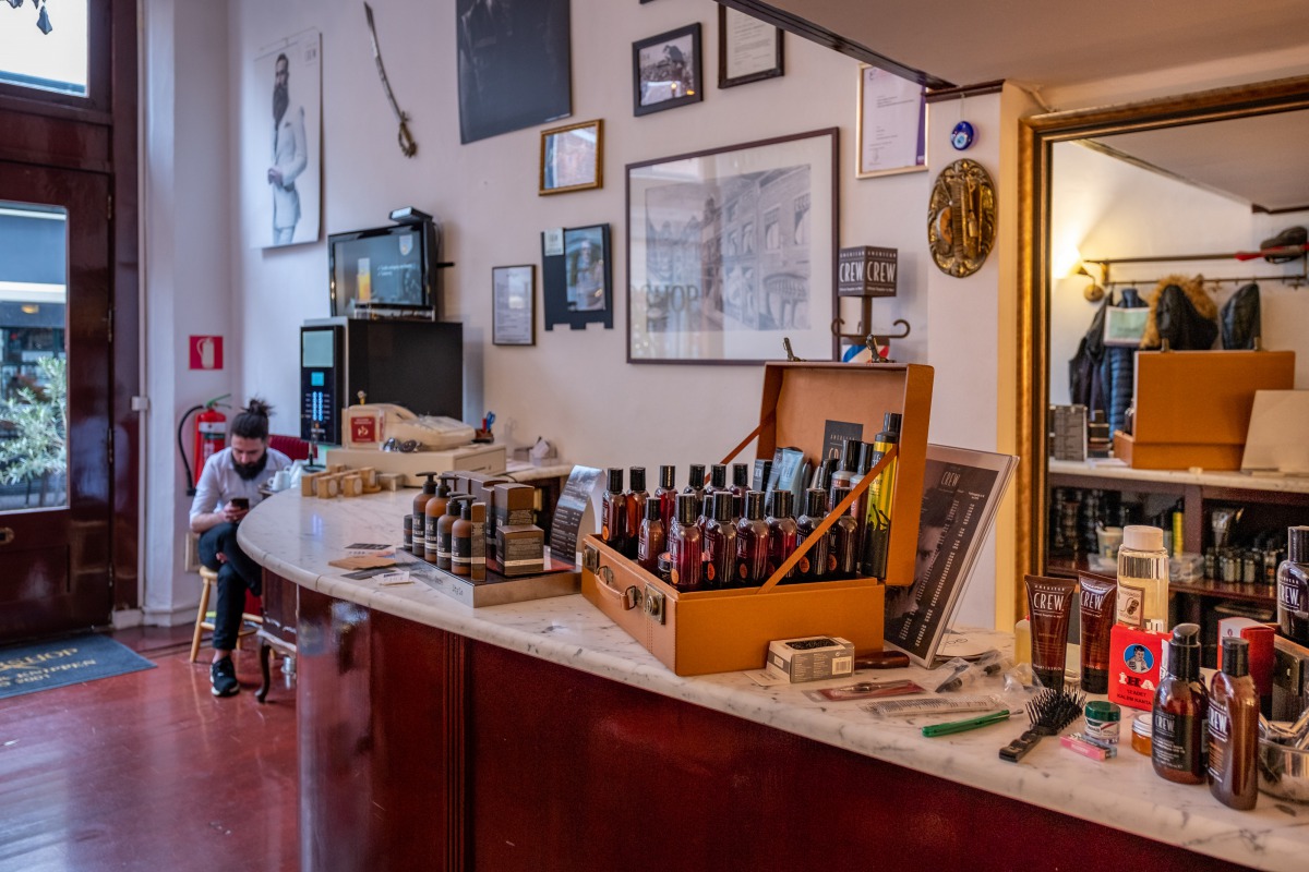 Interieur van Sherwany Barbershop — marmeren toonbank met verzorgingsproducten en vintage sfeer